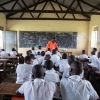 Et typisk klasseværelse i Uganda. Eleverne i skoleuniformer sidder ved pulte med deres skrivehæfter. – Foto: Heidi Brehm