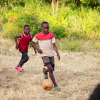 Lige uden for Maweni ligger en græsplæne bag et pigtrådshegn. Her spiller alle børnene fodbold sammen. Foto: Hans Bach.