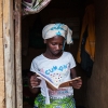 Fatoumata er glad for at læse. Her står hun i døren med en af sine skolebøger. Foto: William Vest-Lillesøe