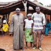 Fatoumata sammen med sin bedstefar og sin onkel. De står foran det overdækkede område, hvor man mødes, hvis der er noget at tale om. Foto: William Vest-Lillesøe