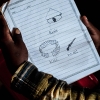 En dreng har lavet små tegninger i sit hæfte og skrevet ordene på sit lokale sprog.  Foto: Pernille Bærendtsen
